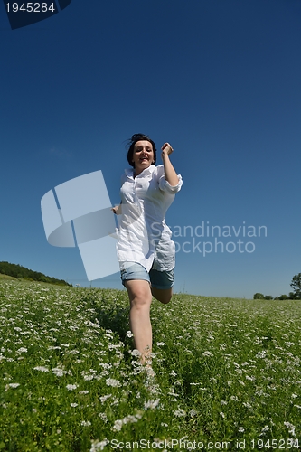 Image of Young happy woman in green field