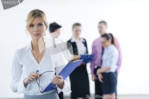 Image of business woman standing with her staff in background