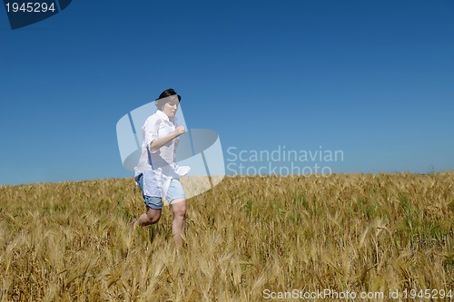 Image of young woman in wheat field at summer
