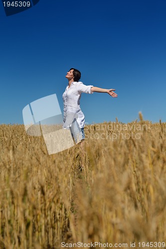 Image of young woman in wheat field at summer
