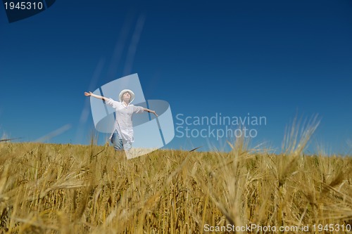 Image of young woman in wheat field at summer