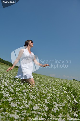 Image of Young happy woman in green field