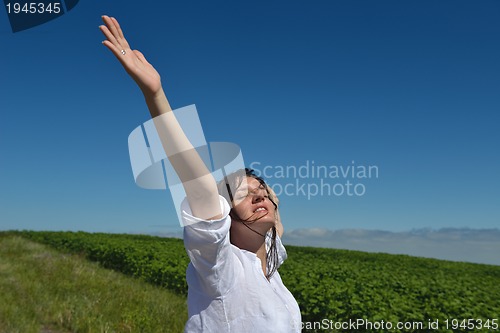 Image of Young happy woman in green field
