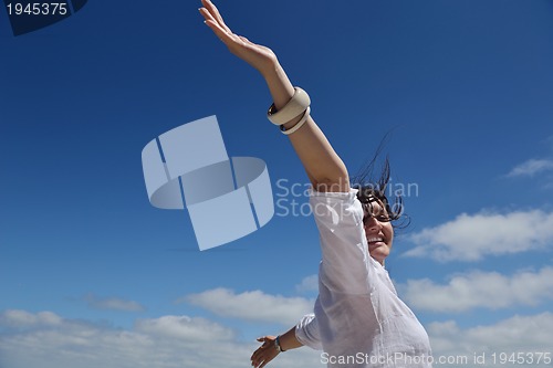 Image of happy young woman with spreading arms to sky