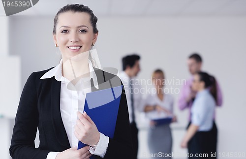 Image of business woman standing with her staff in background