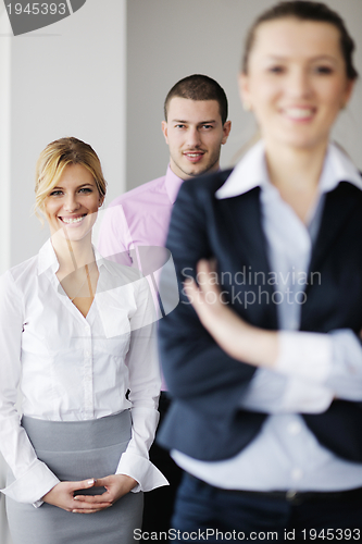 Image of business woman standing with her staff in background