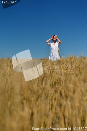 Image of young woman in wheat field at summer
