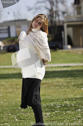 Image of happy young pregnant woman outdoor
