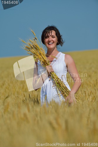 Image of young woman in wheat field at summer