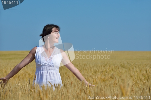 Image of young woman in wheat field at summer