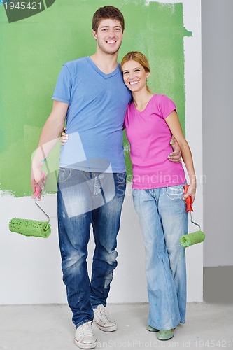 Image of happy couple paint wall at new home