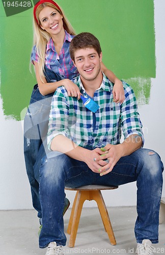 Image of happy couple paint wall at new home