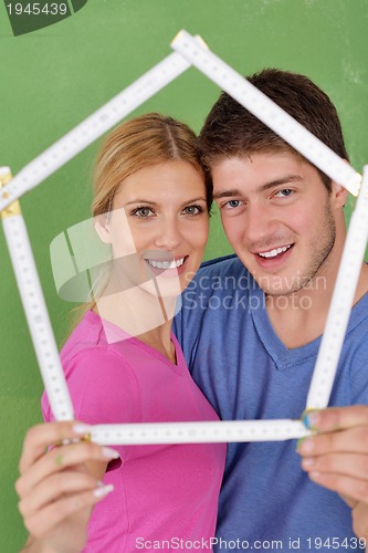 Image of happy couple paint wall at new home