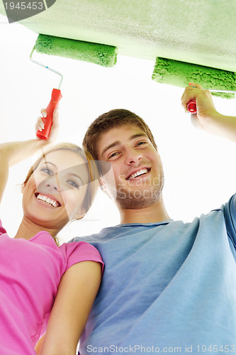 Image of happy couple paint wall at new home