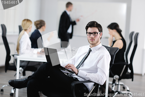 Image of Portrait of a handsome young business man with colleagues in bac