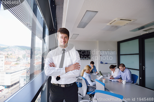 Image of business man  on a meeting in offce with colleagues in backgroun