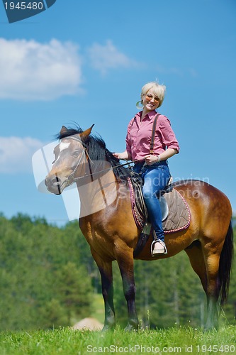 Image of happy woman  on  horse