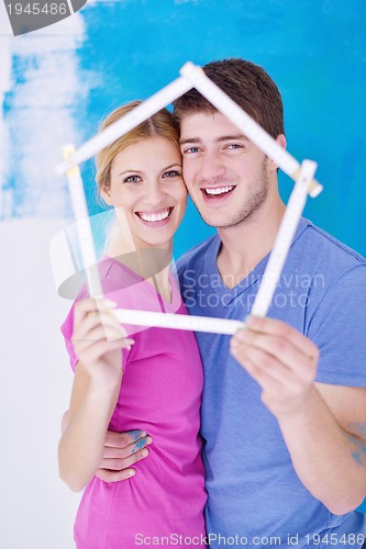 Image of happy couple paint wall at new home