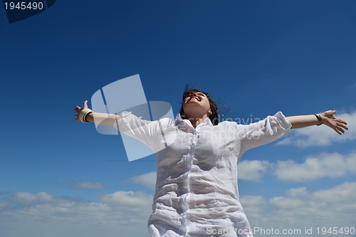 Image of young woman with spreading arms to sky