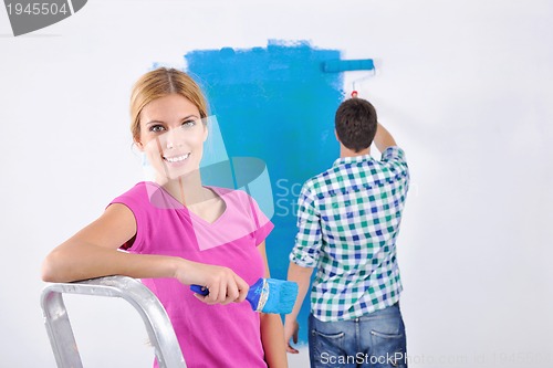 Image of happy couple paint wall at new home