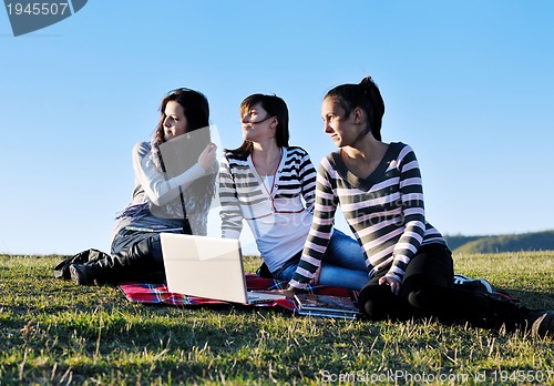 Image of group of teens working on laptop outdoor