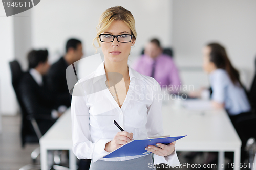 Image of business woman standing with her staff in background
