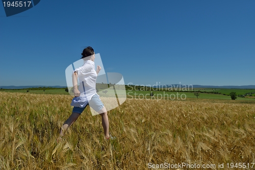 Image of young woman in wheat field at summer
