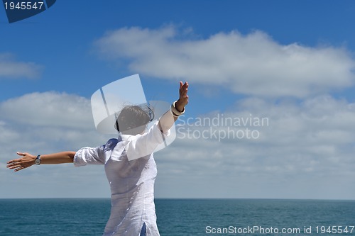 Image of happy young woman with spreading arms to sky