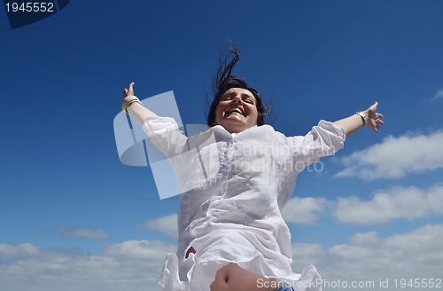 Image of happy young woman with spreading arms to sky