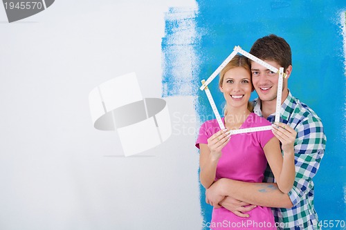 Image of happy couple paint wall at new home