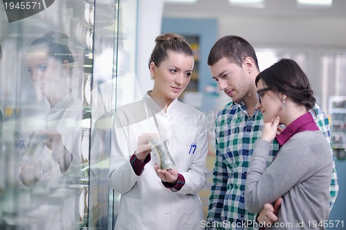 Image of pharmacist suggesting medical drug to buyer in pharmacy drugstor