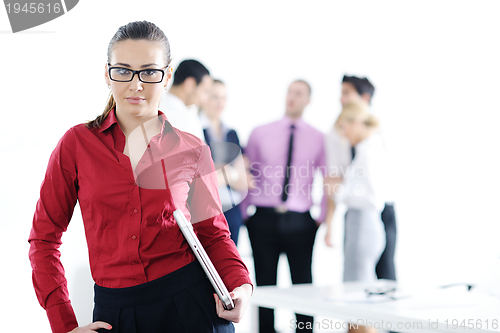 Image of business woman standing with her staff in background