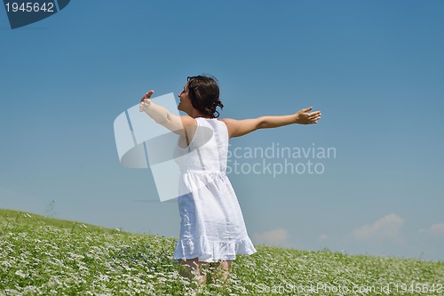 Image of Young happy woman in green field