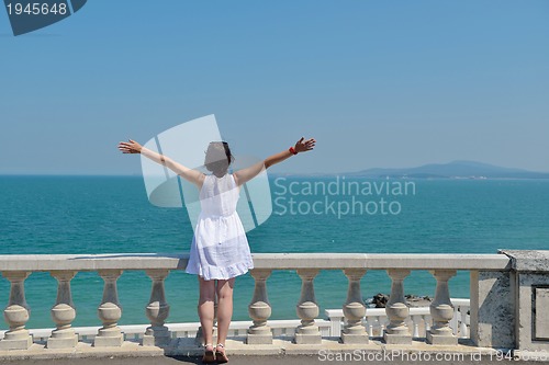Image of happy young woman with spreading arms to sky