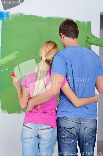 Image of happy couple paint wall at new home