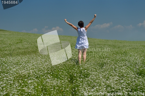 Image of Young happy woman in green field