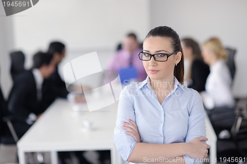 Image of business woman standing with her staff in background