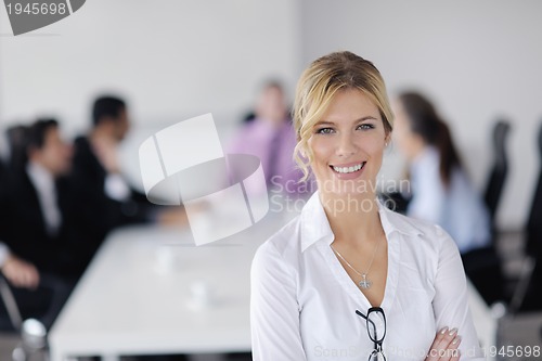 Image of business woman standing with her staff in background