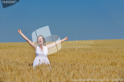 Image of young woman in wheat field at summer