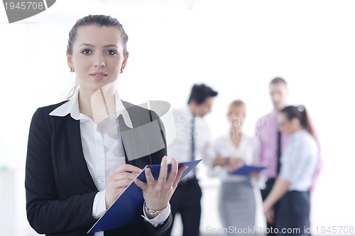 Image of business woman standing with her staff in background