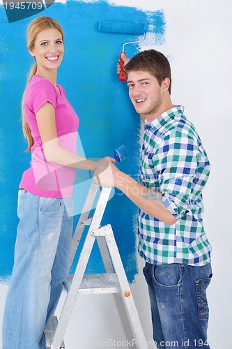 Image of happy couple paint wall at new home