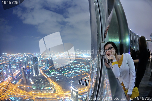 Image of beautiful woman portrait with big city at night in background