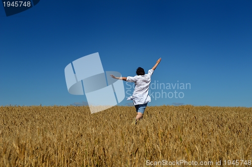 Image of young woman in wheat field at summer