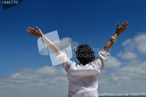 Image of young woman with spreading arms to sky
