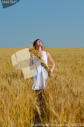 Image of young woman in wheat field at summer