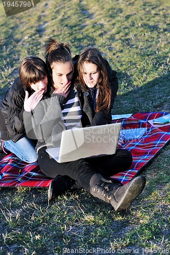 Image of group of teens working on laptop outdoor