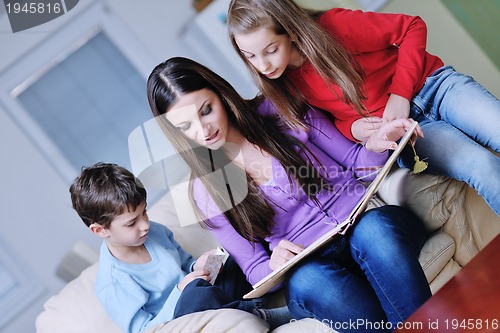 Image of young mom play with their kids at home and reading book