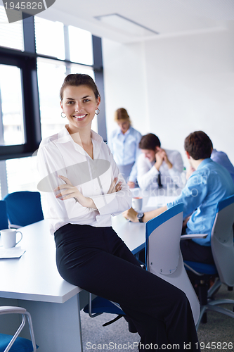 Image of business woman with her staff in background at office