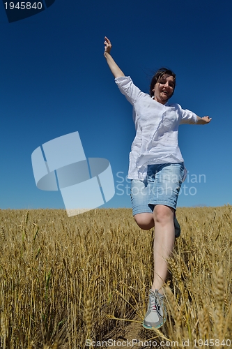 Image of young woman in wheat field at summer
