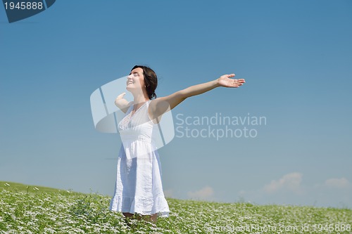 Image of Young happy woman in green field